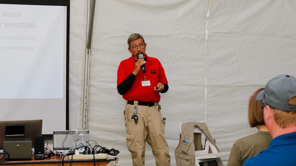 Mas lecturing on affirmative defense at Tac-Con in 2021, with a slide from the Amber Guyger case in the background.