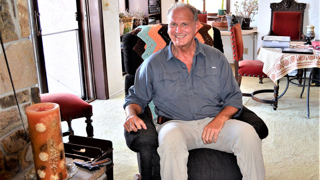The author sits in Colonel Jeff Cooper’s La-Z-Boy with his 1911 on the fireplace.