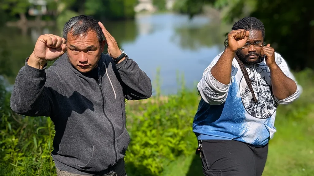 Both step forward into an outside middle block, driving from the inside out, blocking with their forearms, support hand raised into a guard position. Rotate and hand outward, twisting the forearm outward to drive an attacking limb away. Do not just raise your arm to absorb a strike like a punching bag. – Blocking a Punch Part 2