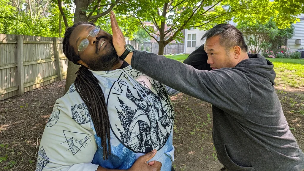 Sam counter strikes Kysean with a palm strike to the face.