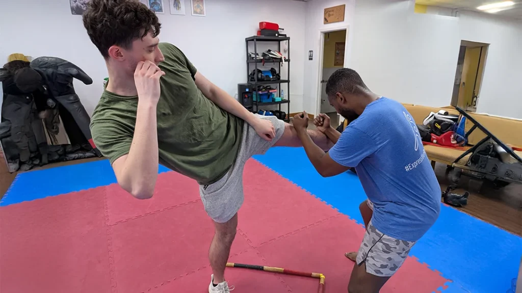 Defensive Footwork: Brian uses his ANGLE 2 V-STEP and double forearm blocks the roundhouse kick.