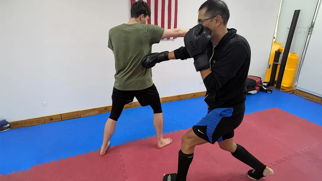 Defensive Footwork: Adam follows up with his own counterpunch and steps back to regain distance. Notice how Adam can see Ben’s ear from this angle.