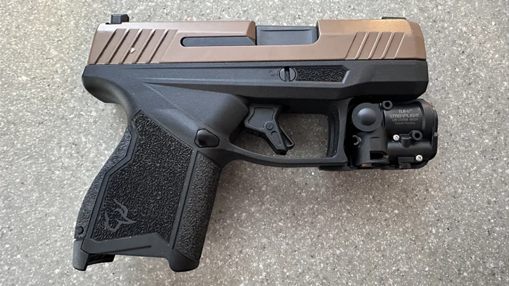 Placing her Taurus flat on the table, the author fit the first half around the trigger guard, inserting the module into the molded surface and making sure the LED faced towards the opening.