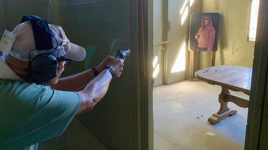 Man using concealment to enter a room with an active shooter.